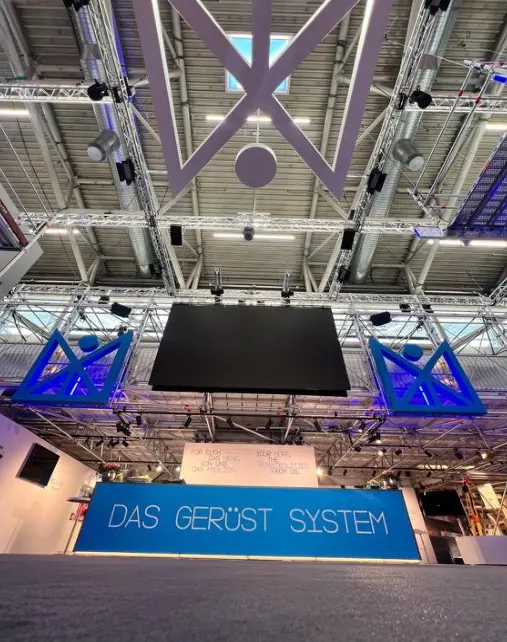 Bühne des Layher-Stands mit dem Schriftzug „Das Gerüst System“ unter einer großen LED-Wand