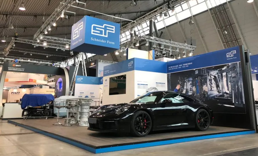 Messestand von Schneider Form mit schwarzem Sportwagen und hängendem Würfel