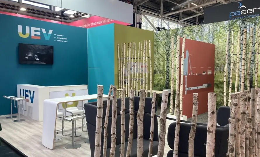 Messestand von UEV mit Theke, Birkenstämmen und Waldmotiv