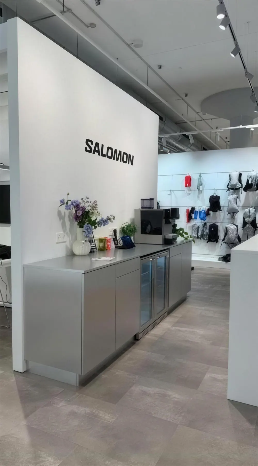 Theke mit Kaffeemaschine vor der weißen Wand mit Salomon-Schriftzug