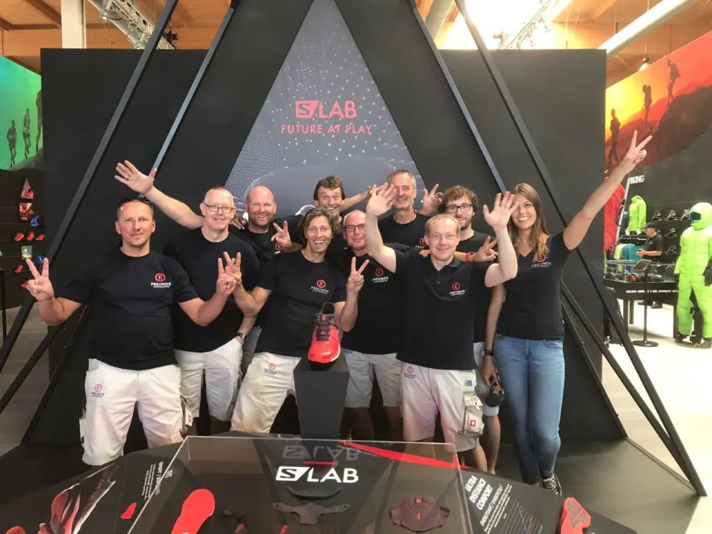 Das Team von FREUNDE Messebau jubelt nach dem Aufbau vor einem fertigen Messestand